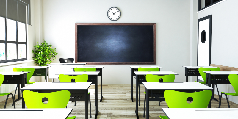 A classroom with modern desks and seats arranged neatly.
