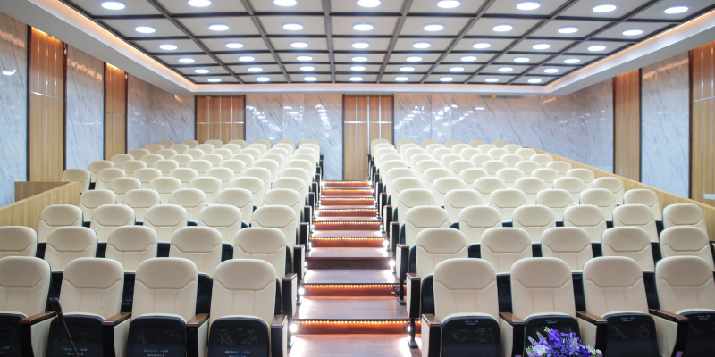 An empty auditorium with seats organized in clean, symmetrical rows.